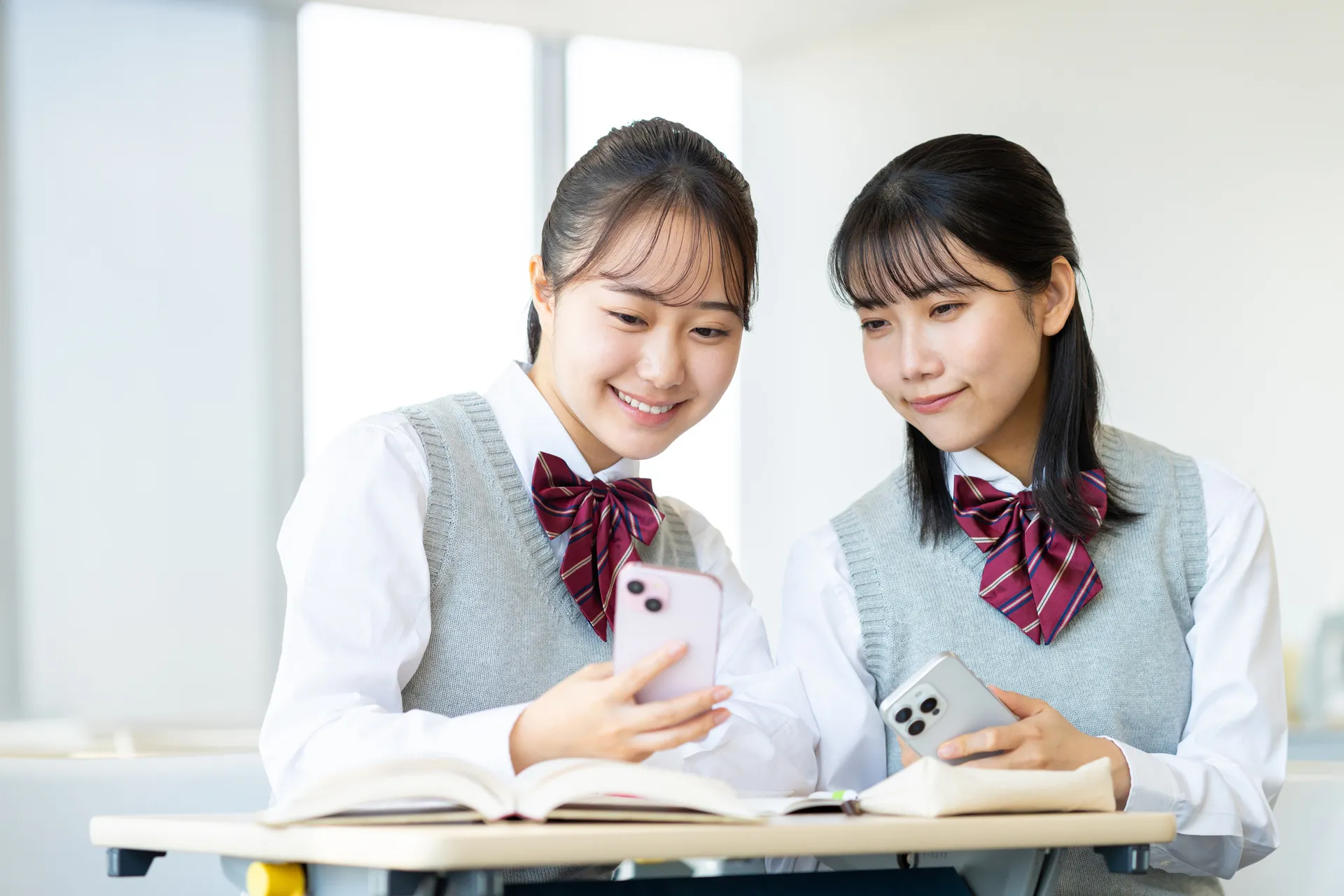 スマートフォンで一緒に学習する生徒たち